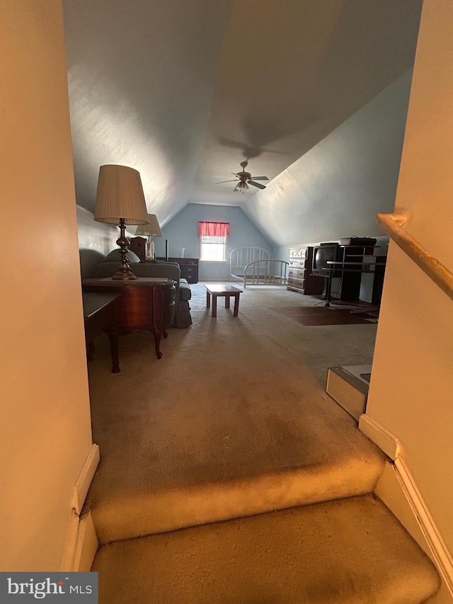 interior space with ceiling fan, vaulted ceiling, and carpet