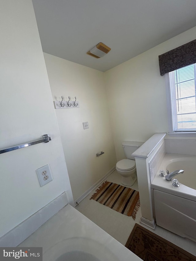 bathroom with toilet and a washtub