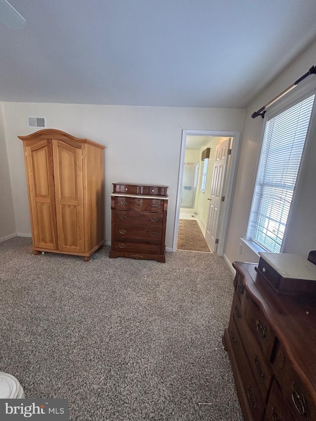 bedroom featuring connected bathroom and carpet