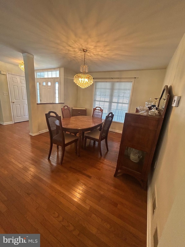 dining area with an inviting chandelier and dark hardwood / wood-style floors