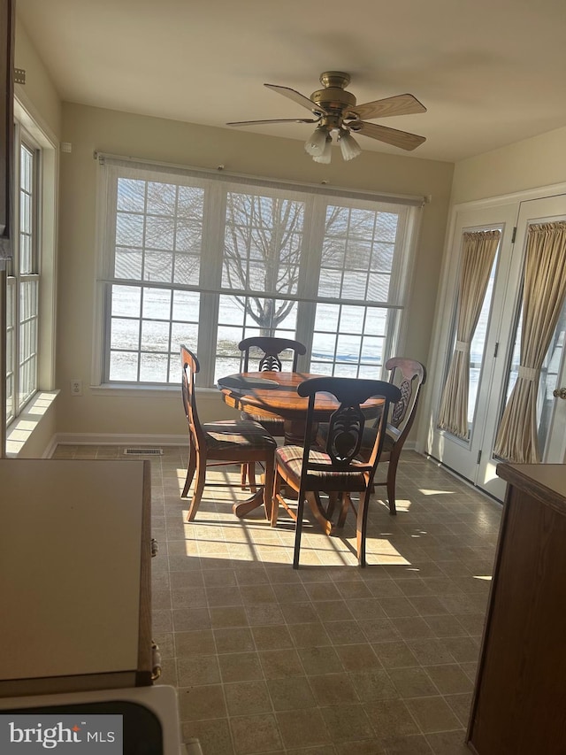 tiled dining space featuring ceiling fan