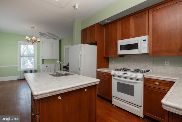 kitchen with sink, white appliances, a kitchen island with sink, radiator heating unit, and tile countertops