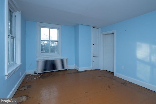 spare room with hardwood / wood-style flooring and radiator heating unit