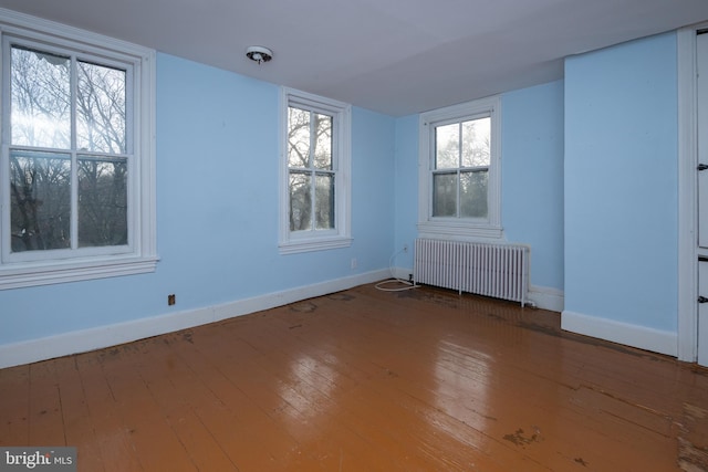 empty room with radiator and hardwood / wood-style flooring