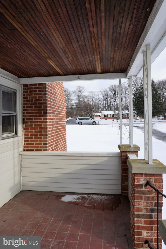 snow covered patio with covered porch