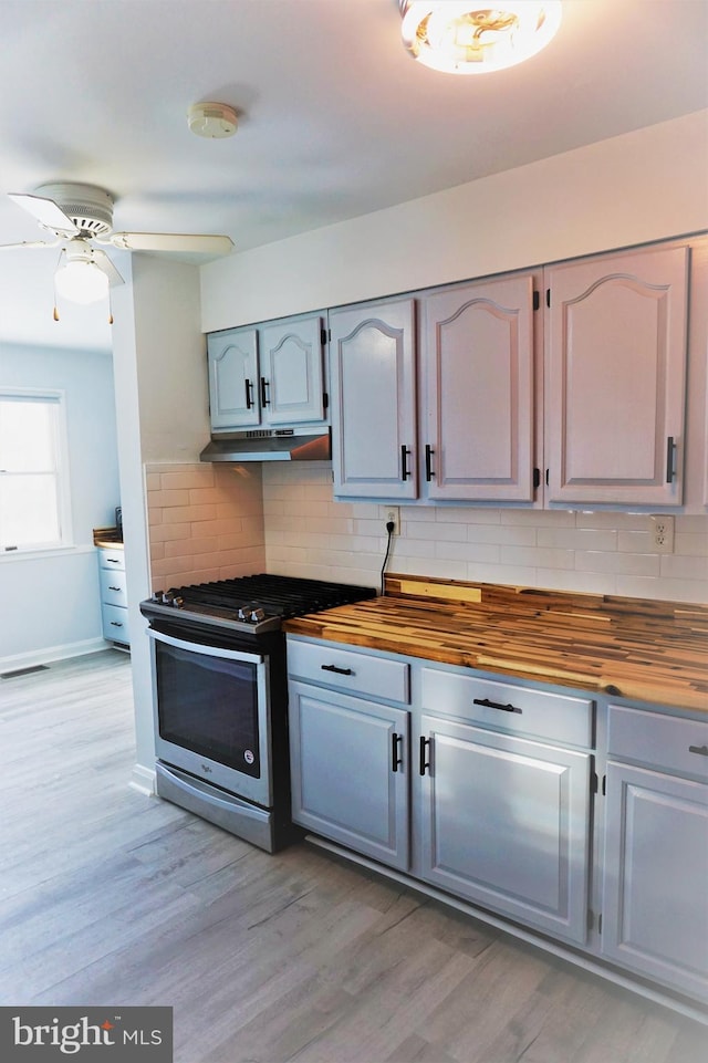 kitchen with wooden counters, gas range, ceiling fan, tasteful backsplash, and light hardwood / wood-style floors