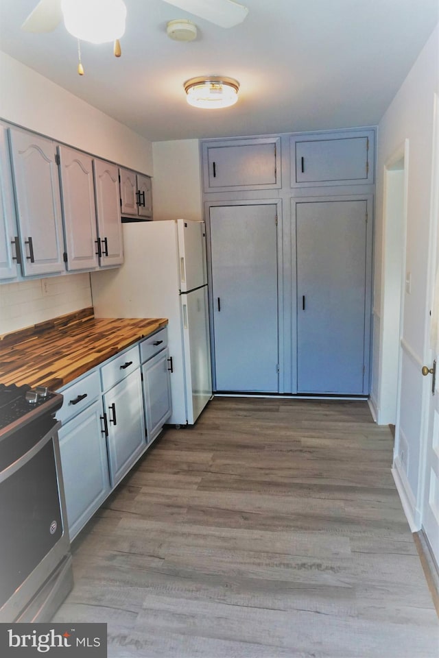 kitchen with wooden counters, gray cabinetry, white refrigerator, light hardwood / wood-style flooring, and black electric range