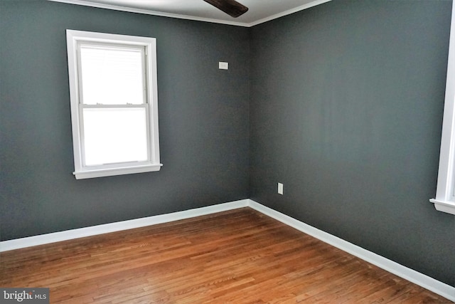 unfurnished room featuring a wealth of natural light, crown molding, ceiling fan, and hardwood / wood-style flooring