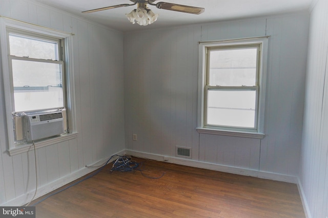 empty room with ceiling fan, cooling unit, and dark hardwood / wood-style flooring