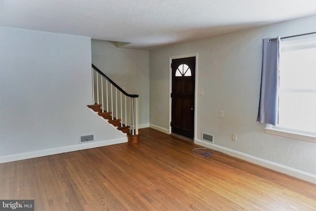 entryway with wood-type flooring and a textured ceiling