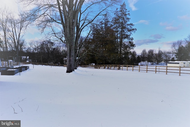 yard covered in snow with a rural view