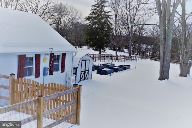 yard layered in snow with a storage shed