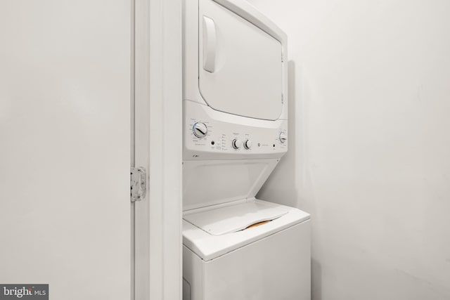 washroom featuring stacked washer and clothes dryer