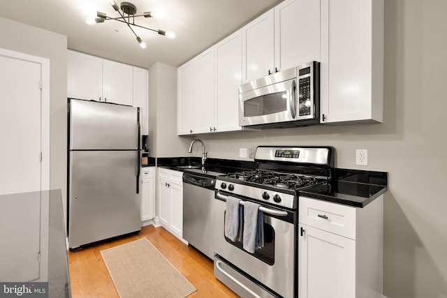 kitchen featuring white cabinetry, light hardwood / wood-style floors, and appliances with stainless steel finishes