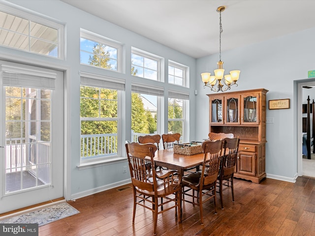 dining area featuring dark hardwood / wood-style flooring and an inviting chandelier