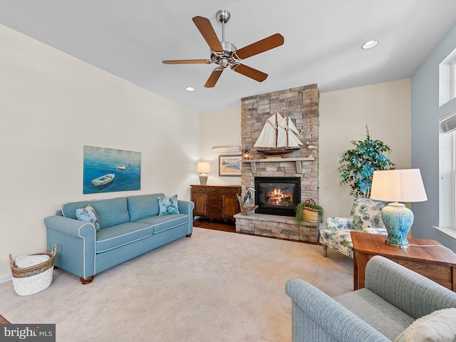 carpeted living room with ceiling fan and a fireplace