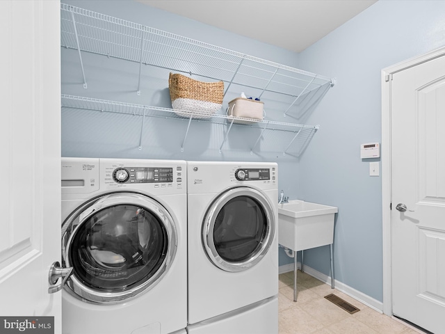 washroom featuring independent washer and dryer and light tile patterned floors