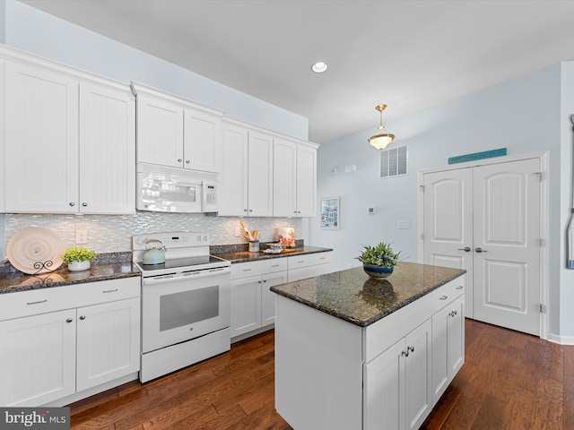 kitchen with white cabinets, dark hardwood / wood-style flooring, dark stone countertops, and white appliances