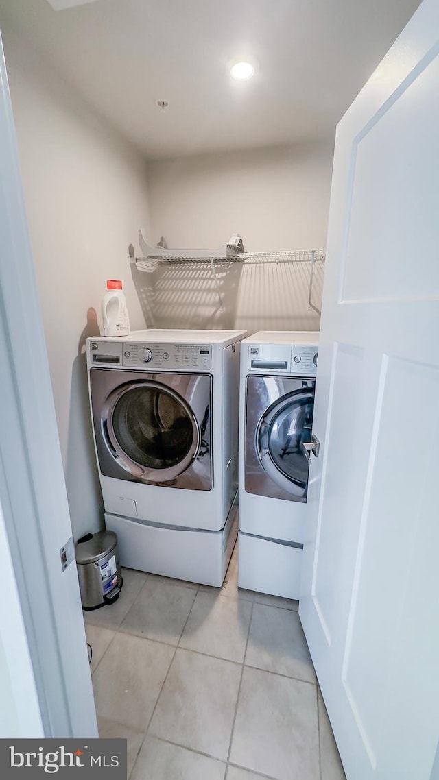 washroom featuring independent washer and dryer and light tile patterned flooring