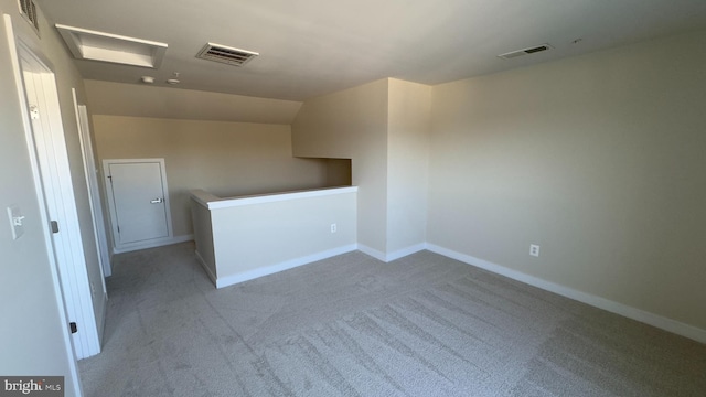 carpeted empty room with vaulted ceiling