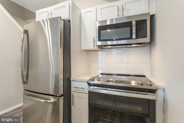 kitchen featuring tasteful backsplash, white cabinets, dark hardwood / wood-style floors, and appliances with stainless steel finishes