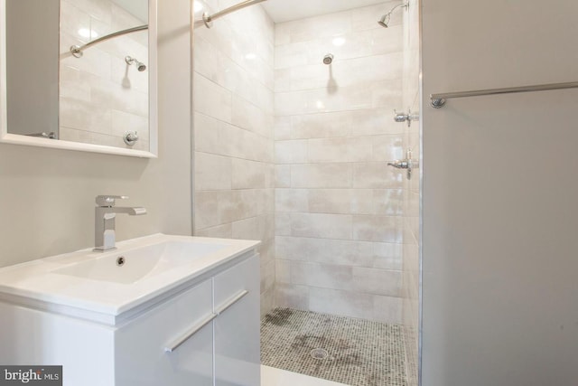 bathroom featuring tiled shower and vanity