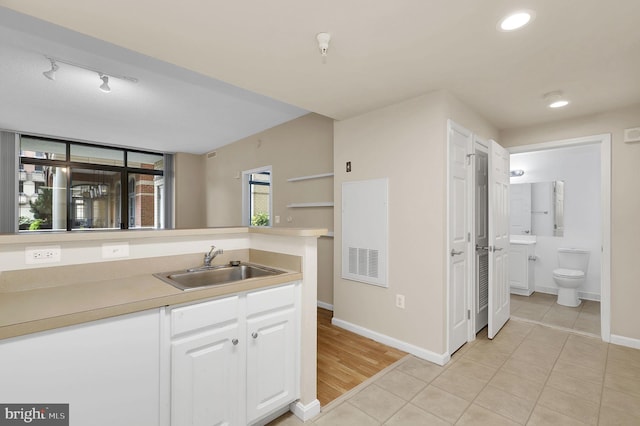 kitchen with white cabinetry, sink, and light tile patterned floors