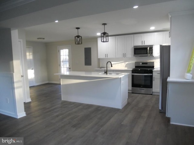 kitchen with a kitchen island with sink, sink, hanging light fixtures, appliances with stainless steel finishes, and white cabinetry