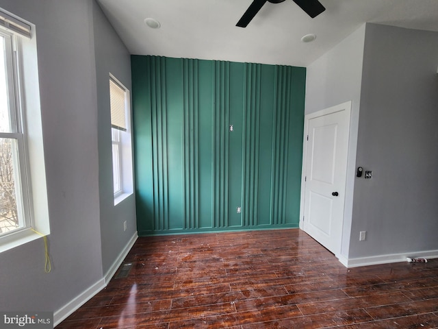 unfurnished room with ceiling fan and dark hardwood / wood-style flooring