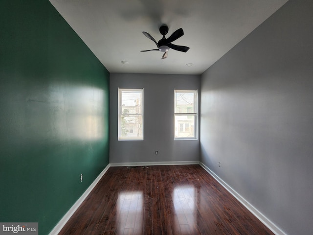 empty room with dark hardwood / wood-style floors and ceiling fan