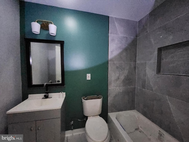 bathroom with vanity, toilet, and tiled shower