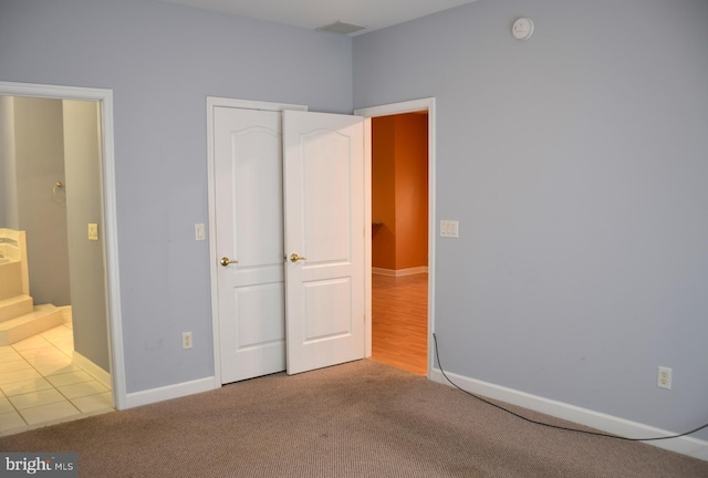 unfurnished bedroom featuring light carpet