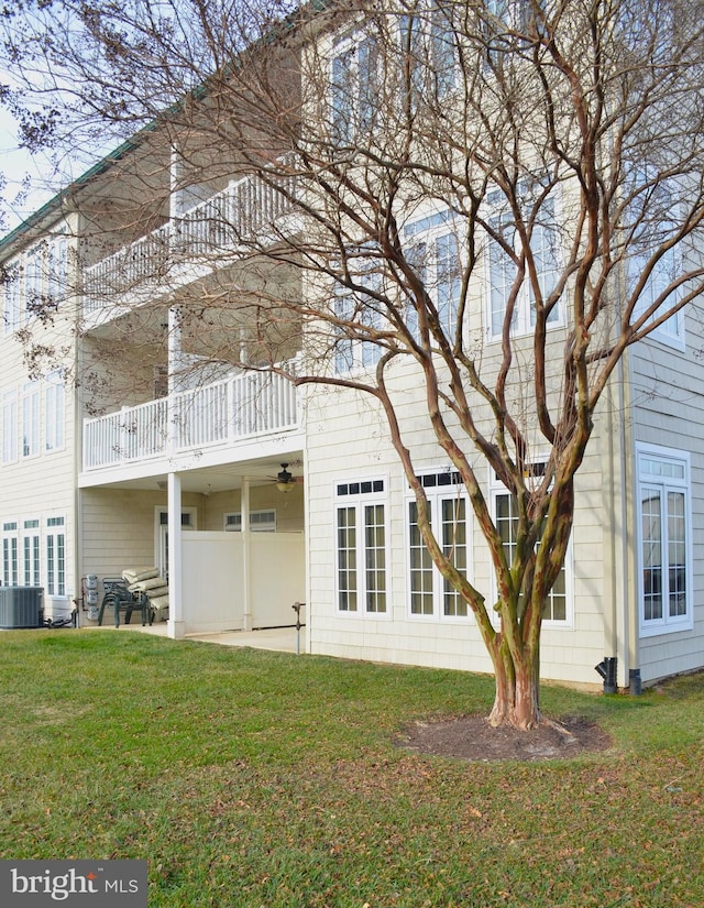 back of house featuring a lawn, a balcony, cooling unit, and a patio