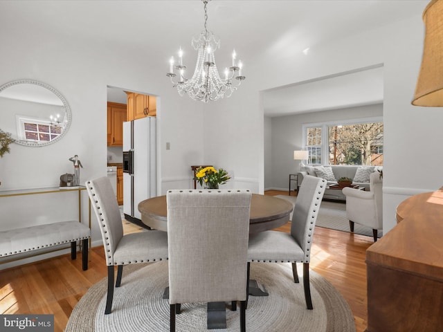 dining space featuring an inviting chandelier and light wood finished floors