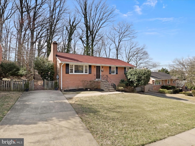 view of front of property featuring brick siding, a chimney, a front lawn, and fence