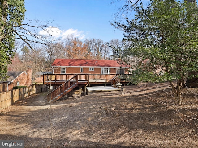 rear view of property featuring fence and a wooden deck