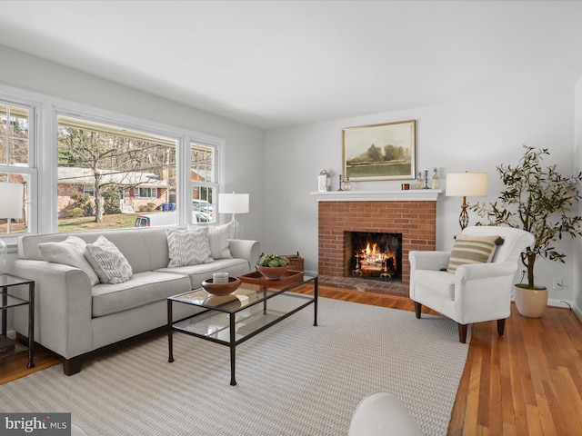 living area featuring a brick fireplace and wood finished floors