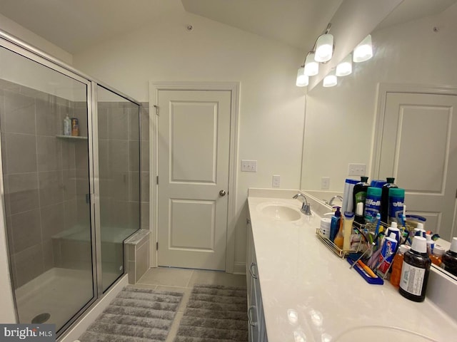 bathroom with tile patterned flooring, vanity, a shower with door, and vaulted ceiling