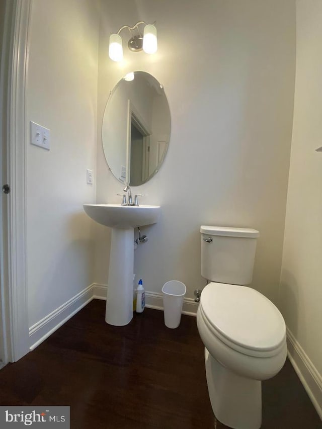 bathroom with hardwood / wood-style flooring, toilet, and sink