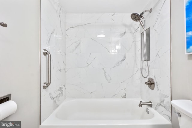 bathroom featuring tiled shower / bath and toilet