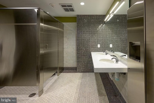 bathroom featuring tile patterned floors, double sink, and walk in shower