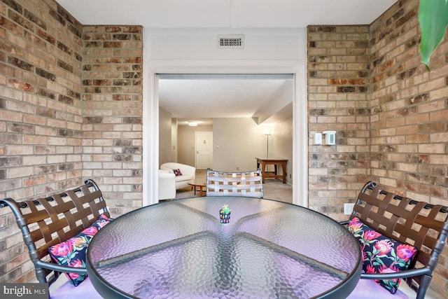 unfurnished dining area with brick wall