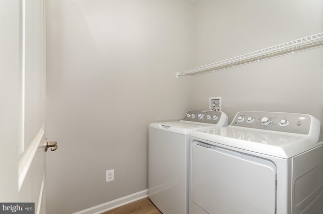 clothes washing area featuring hardwood / wood-style floors and washing machine and dryer