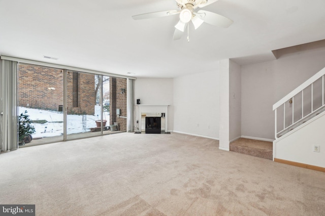 unfurnished living room featuring floor to ceiling windows, ceiling fan, and light colored carpet