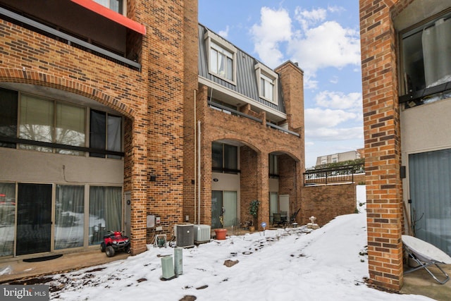 snow covered property with cooling unit