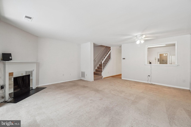 unfurnished living room with ceiling fan and light colored carpet