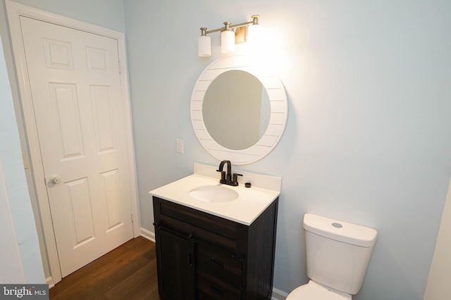 bathroom with vanity, hardwood / wood-style flooring, and toilet