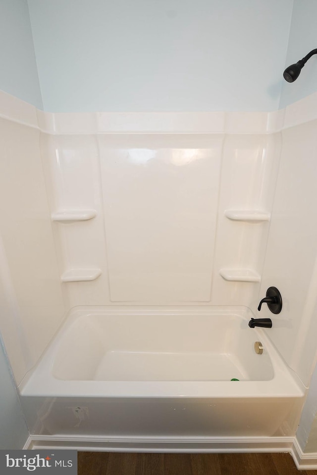 bathroom featuring wood-type flooring and washtub / shower combination