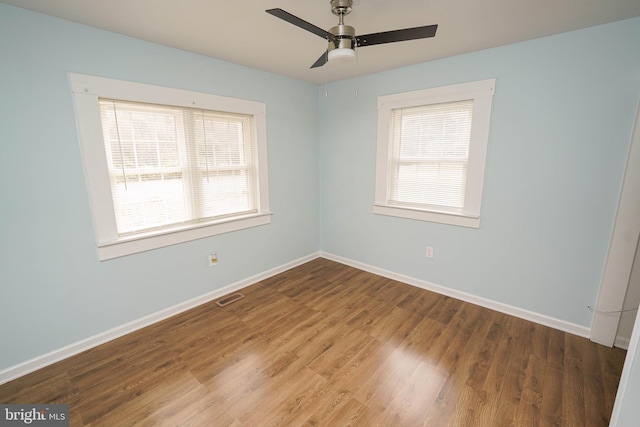 unfurnished room with hardwood / wood-style flooring, ceiling fan, and a healthy amount of sunlight