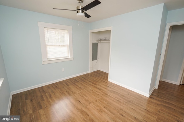 unfurnished bedroom with hardwood / wood-style floors, electric panel, a closet, and ceiling fan